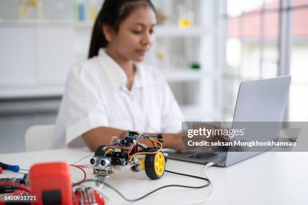 on the laptop, schoolgirl starting the open-source hardware and software platform for a test drive of robotic car she made - open source development stock pictures, royalty-free photos & images