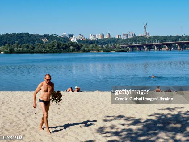 People sunbathe on a city beach at the Dnipro River on August 24, 2022 in Kyiv, Ukraine. The threat of Russian missile strikes on Kyiv remains,...