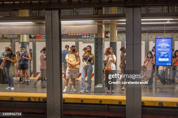 people waiting on a subway platform - pedestrian tunnel stock pictures, royalty-free photos & images