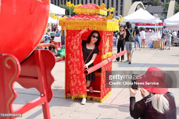 Tourist experiences bridal sedan chair during the 3rd Toronto Dragon Festival on September 3, 2022 in Toronto, Canada.