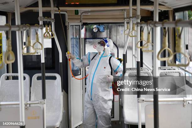 Staff member wearing personal protective equipment disinfects a bus at a bus station on September 5, 2022 in Chengdu, Sichuan Province of China.