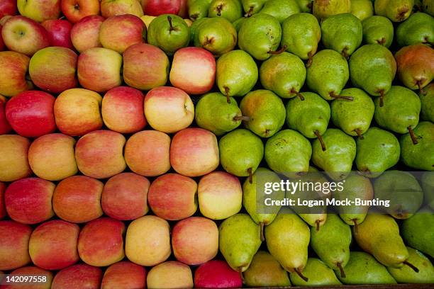 red apples and green pears lay in a pile at a fruit stand in maryland, usa. - poire photos et images de collection