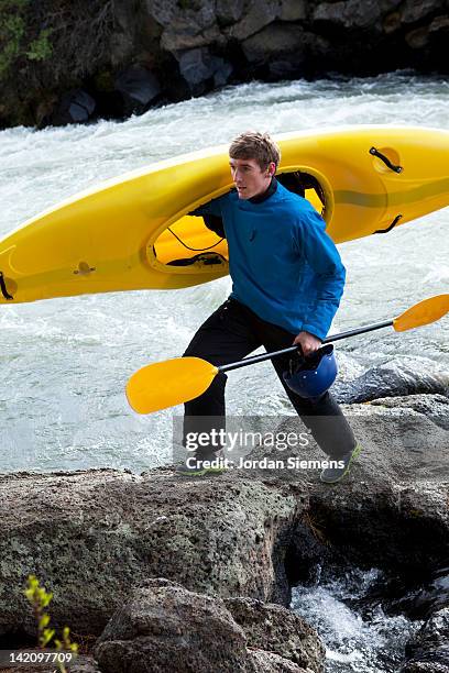 man hikes along river with kayak. - carrying canoe stock pictures, royalty-free photos & images