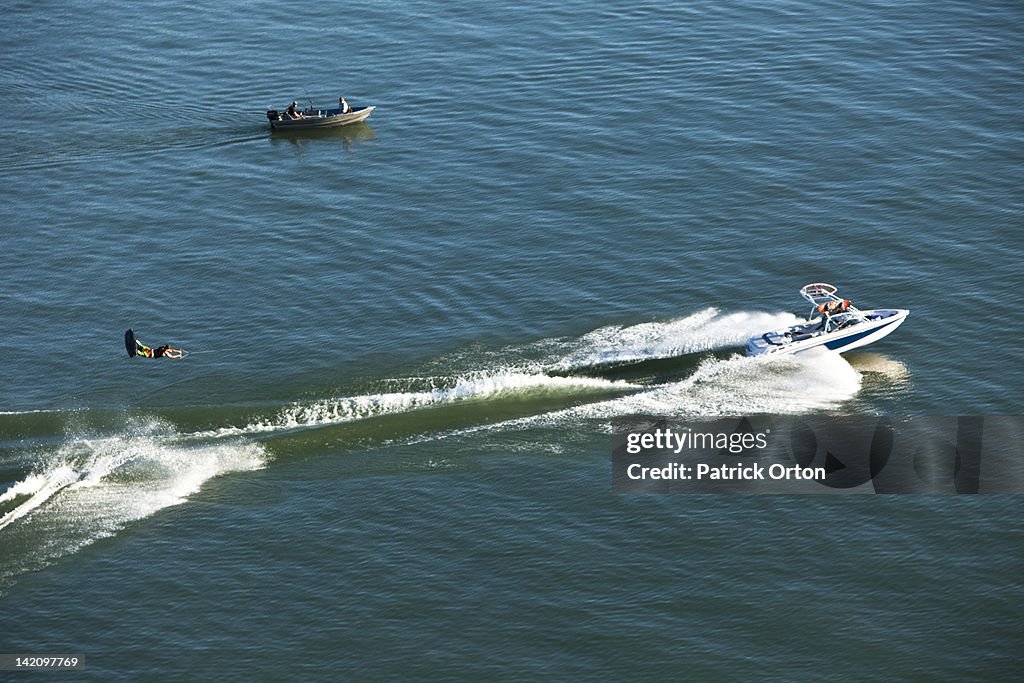 A athletic wakeboarder jumps the wake going huge on a calm day in Idaho.