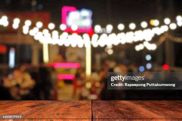 wood table top with blurred of lighting in night street outdoor night food and beer space for relax chill out and hang out - blurred motion restaurant stock pictures, royalty-free photos & images