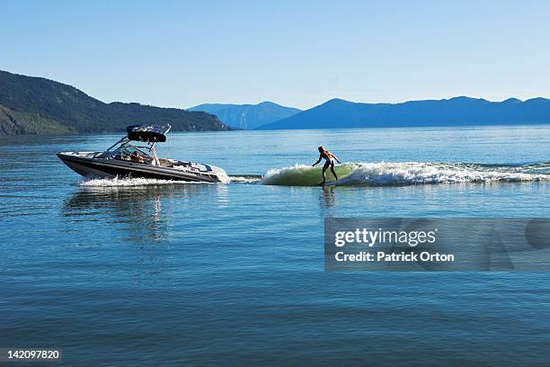 a sexy woman wakesurfs behind a wakeboard boat on a sunny day in idaho. - waterskiing stock pictures, royalty-free photos & images
