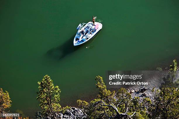 a man coils his wakeboard rope as his sexy girlfriend drives the boat. shot from above in idaho. - pend orielle lake stock pictures, royalty-free photos & images