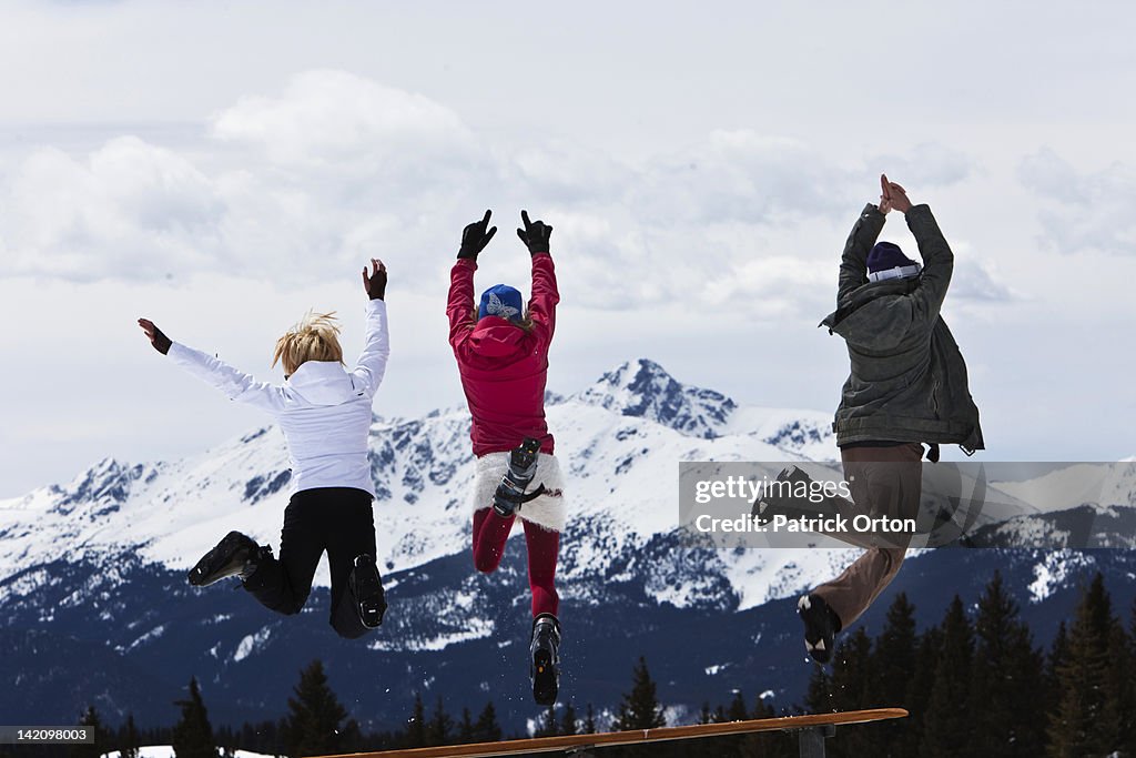 Three beautiful women having fun jump off a picnic table in Colorado.