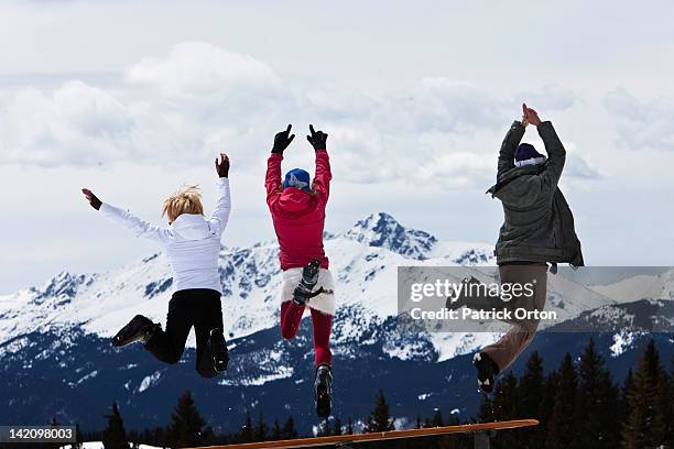 three beautiful women having fun jump off a picnic table in colorado. - apres ski imagens e fotografias de stock