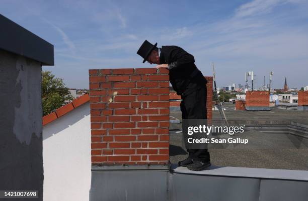 Chimney sweep Norbert Skrobek peers into a chimney opening on the roof of an apartment building on September 05, 2022 in Berlin, Germany. Skrobek...