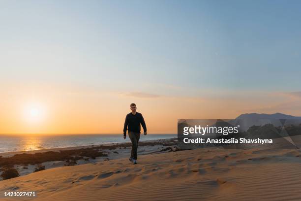 man traveler contemplating the scenic sunset above the sand dunes by the sea in turkey - patara stock pictures, royalty-free photos & images