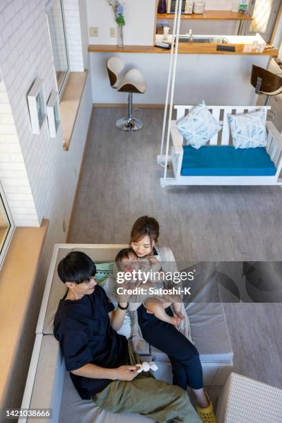 high angle view of family with one child playing together in resort hotel room - kameelkleurig stockfoto's en -beelden