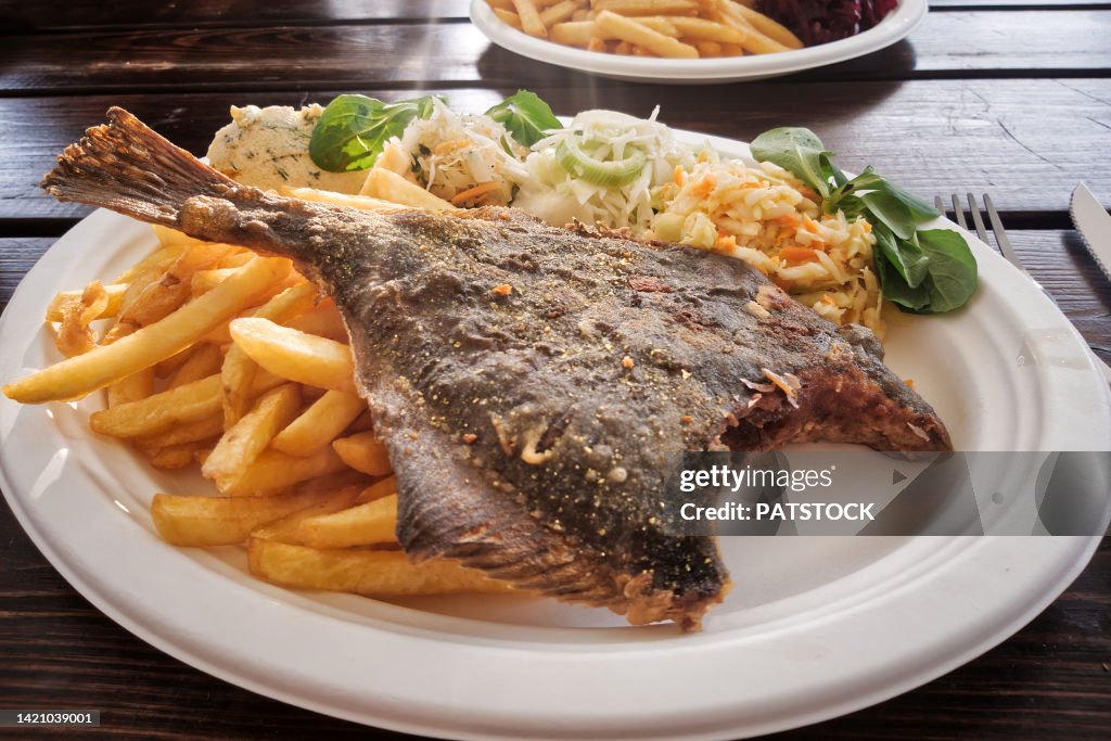 Fried flounder fish with French fries and salad.