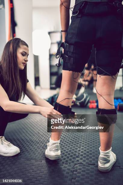 leg workout ready to begin for female with ems bodysuit - female muscle calves stock pictures, royalty-free photos & images