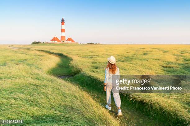 woman at westerheversand lighthouse, germany. - mar de wadden fotografías e imágenes de stock