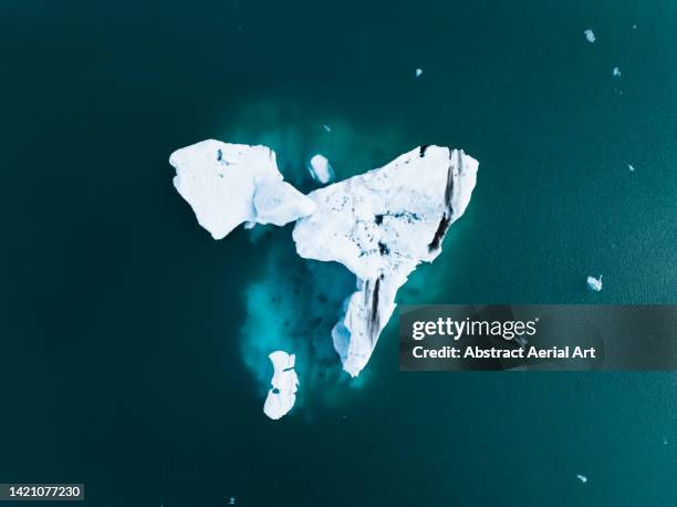 aerial photo looking down on an iceberg in jökulsárlón lagoon, iceland - cambio climático fotografías e imágenes de stock