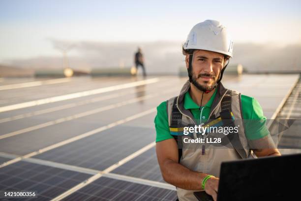 checking productivity at solar power plant with laptop - solar panel installation stock pictures, royalty-free photos & images