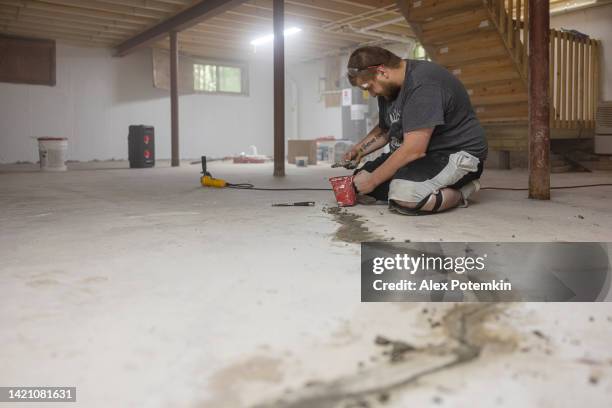 basement waterproofing. worker sealing cracks in basement floor to prevent flooding and mold. - flooded basement imagens e fotografias de stock