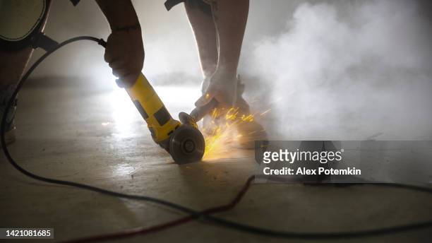 dust and sparkles producing by angle grinder used to groove cracks for waterproofing. - stamped concrete stockfoto's en -beelden