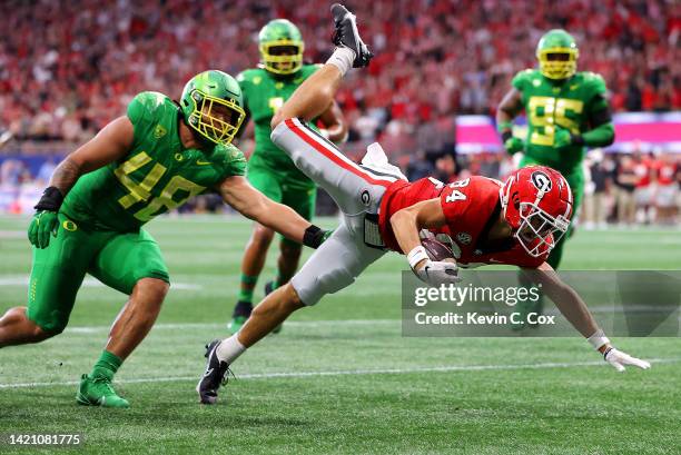 Ladd McConkey of the Georgia Bulldogs leaps in an attempt to score past Treven Ma'ae of the Oregon Ducks during the first quarter of the Chick-fil-A...