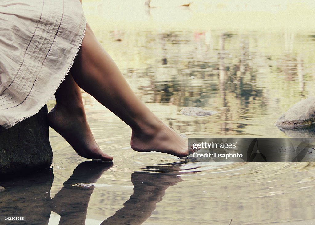 Woman feet reflection on water