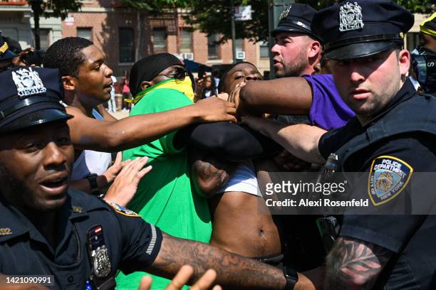 Members of the NYPD break up a fight between two participants in the annual West Indian Day parade on September 5, 2022 in the Brooklyn Borough of...