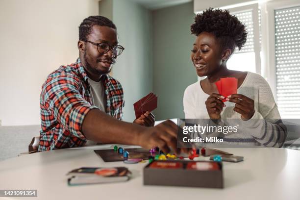 young people enjoying at home and playing board game - bordspel stockfoto's en -beelden