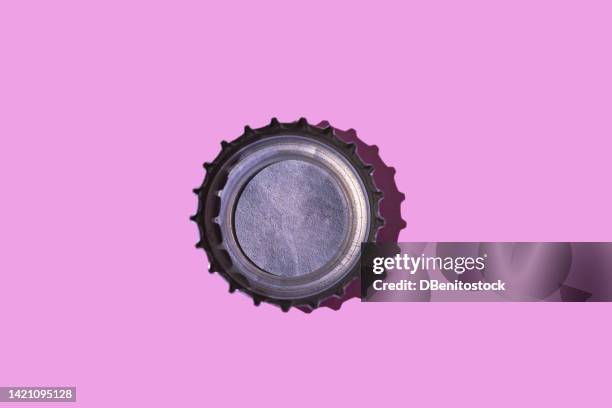 top of a bottle facing up, on a pink background. beverage, alcohol, soda, soft drink, metal, industry, beer and collectibles concept. - tappo birra foto e immagini stock