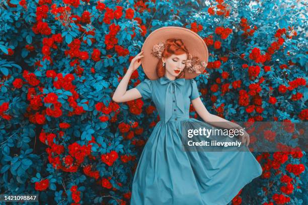 awesome redhead model expresses emotions. valentines day background. fabulous retro girl with red lips in mint dress on awesome summer background. woman portrait. roses bush. - salon chic imagens e fotografias de stock