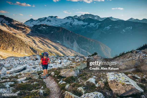 a female backpacker walks on a trail in the high alpine in the selkirk mountains - off the beaten path foto e immagini stock