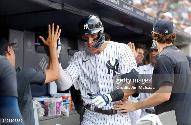 Aaron Judge of the New York Yankees celebrates his two- run home run in the sixth inning against the Minnesota Twins with his teammates in the dugout...