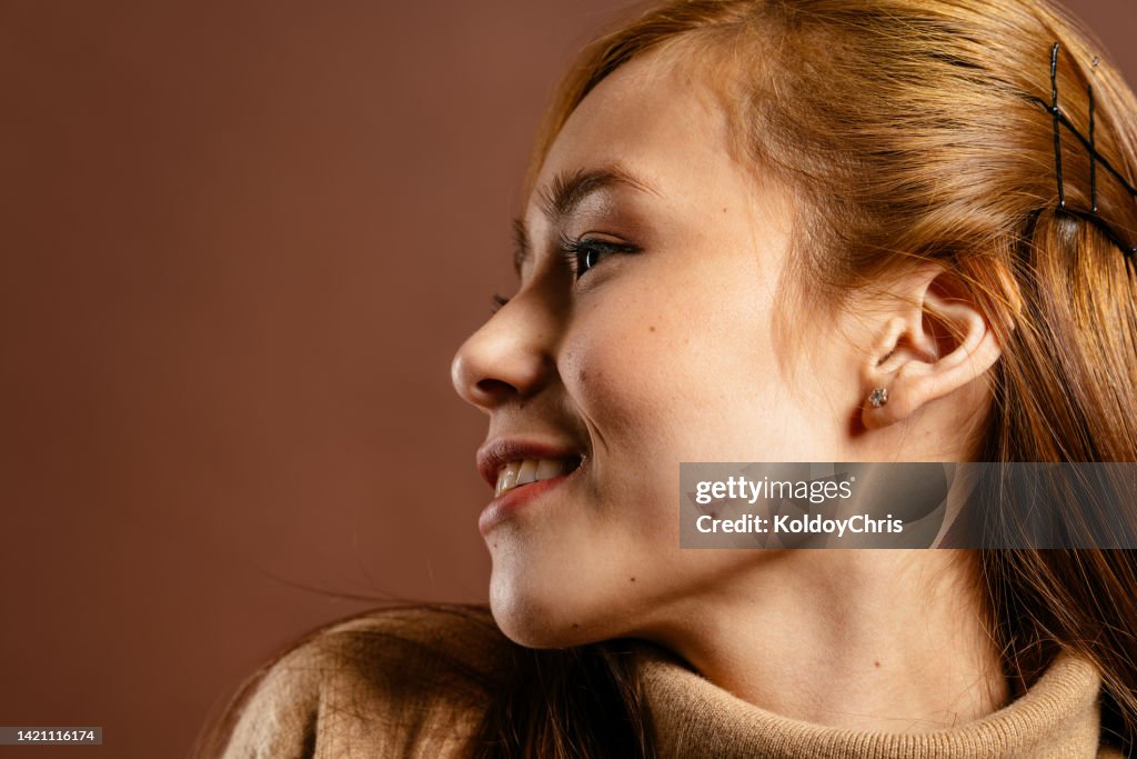 Young Asian woman in profile smiling with buckles in hair