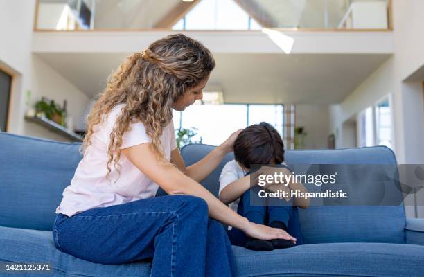 loving mother comforting her sad son at home - tantrum stock pictures, royalty-free photos & images