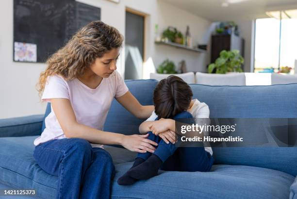 loving mother trying to come down her sad son - sad child and parent stock pictures, royalty-free photos & images