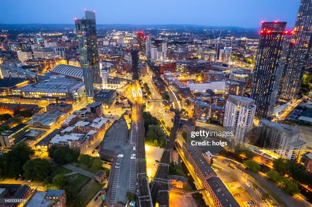 Manchester United Kingdom Luftaufnahme moderner Gebäude mit viel Counstruction im zentralen Bereich der Stadt mit historischen Kanälen und Eisenbahnen im Vordergrund bei Nacht