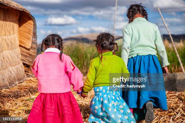 happy children on uros floating island, lake tititcaca, peru - uroseilanden stockfoto's en -beelden