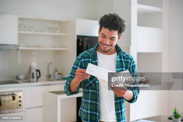 happy man reading good news in a letter in the mail - reading letter stock pictures, royalty-free photos & images