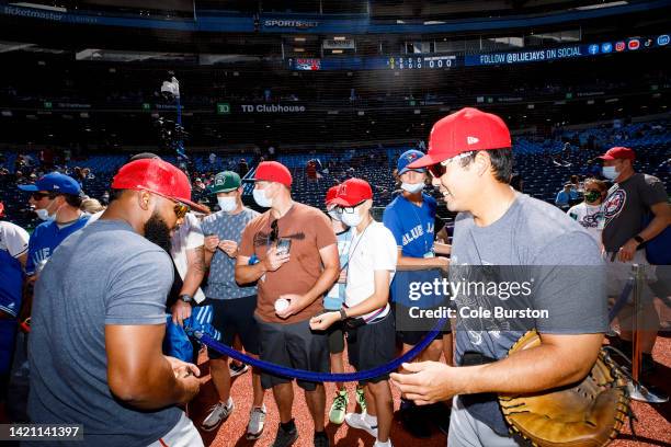 Fans wait for autographs from Luis Rengifo and Kurt Suzuki of the Los Angeles Angels during the Los Angeles Angels batting practice ahead of their...