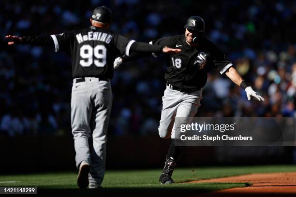 Pollock of the Chicago White Sox celebrates his solo home run with third base coach Joe McEwing in the second inning against the Seattle Mariners at...