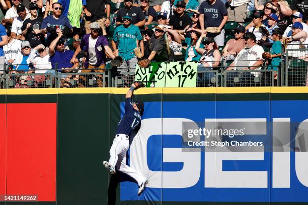 Mitch Haniger of the Seattle Mariners comes up short on a two-run home run off the bat of Elvis Andrus of the Chicago White Sox in the third inning...