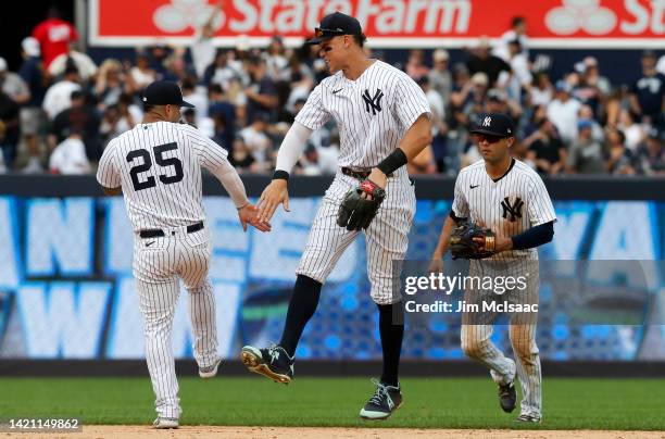 Gleyber Torres, Aaron Judge and Isiah Kiner-Falefa of the New York Yankees celebrate after defeating the Minnesota Twins at Yankee Stadium on...
