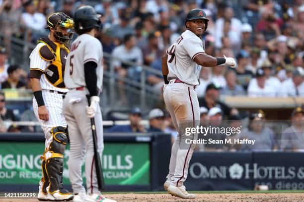 Stone Garrett reacts with Alek Thomas of the Arizona Diamondbacks after hitting a solo homerun as Austin Nola of the San Diego Padres looks on during...