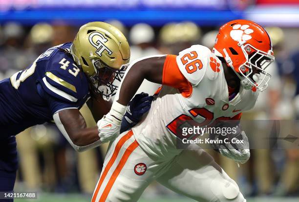 Phil Mafah of the Clemson Tigers rushes away from Noah Collins of the Georgia Tech Yellow Jackets during the second quarter at Mercedes-Benz Stadium...