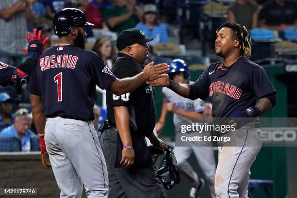 Amed Rosario and Jose Ramirez of the Cleveland Guardians celebrate after scoring on an Oscar Gonzalez two-run double in the 10th inning against the...