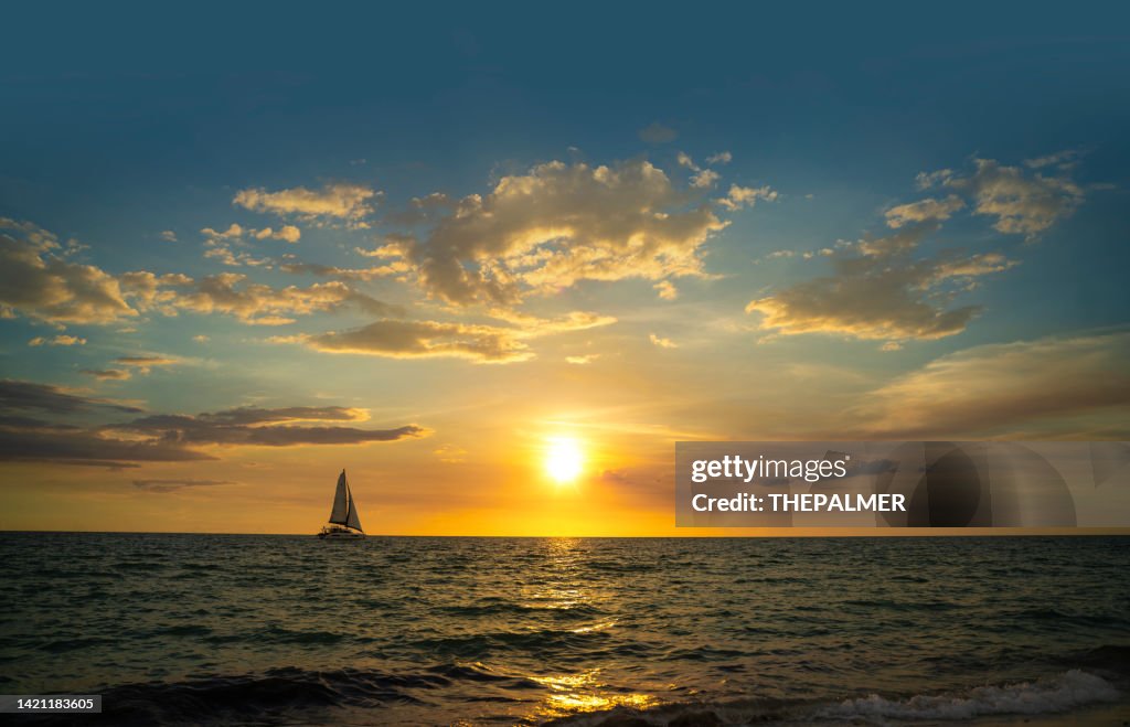 Catamaran navigating at sunset in Naples beach