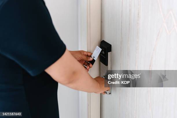 close-up of woman hand is opening a door with card key - door close button stock-fotos und bilder