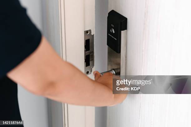 close-up of woman hand is opening a door in apartment - door close button stock-fotos und bilder