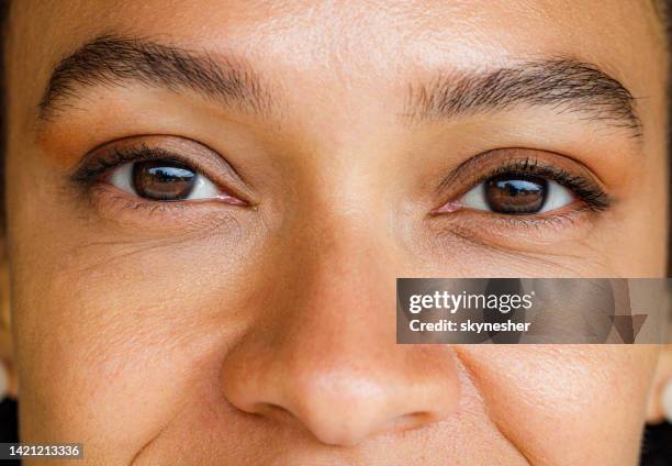 close up of black woman with brown eyes. - human nose stockfoto's en -beelden