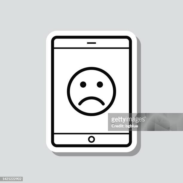 stockillustraties, clipart, cartoons en iconen met tablet pc with sad emoji. icon sticker on gray background - disappointing phone