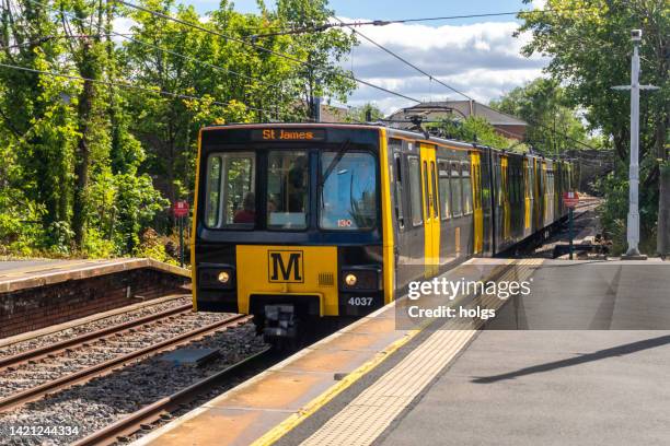 newcastle united kingdom metro train arrives as a station platform outside the city center with passengers and a driver visible onboard - tyne and wear stock pictures, royalty-free photos & images